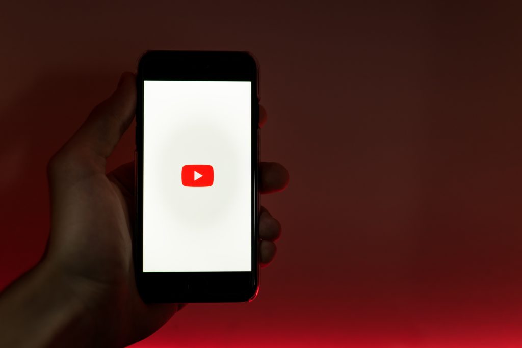 Youtuber tinand in mana Telefon cu ecranul deschis pe Youtube
