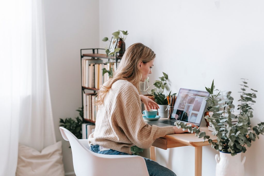 O femeie stând la birou cu un laptop și o ceașcă de cafea de Black Friday