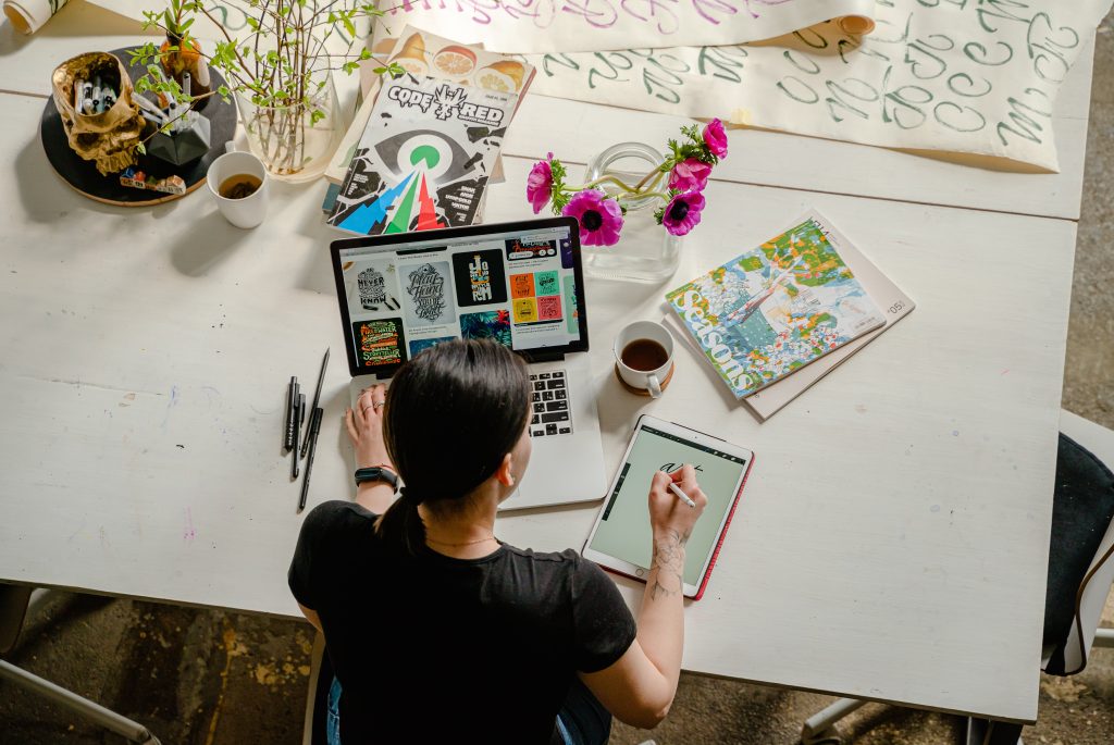 O femeie care are un laptop și o tabletă și vrea să facă bani online în 2024.