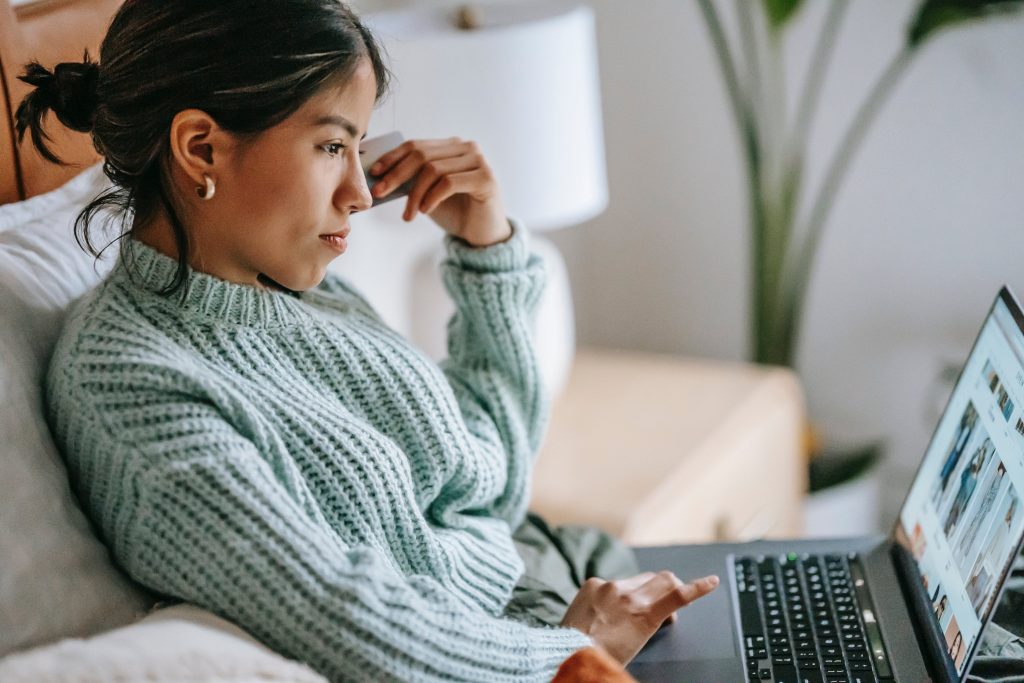 O femeie cu laptopul în brațe ce-și dorește să facă bani online în 2024.